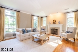 Bright and Airy formal living room with transom windows, beautiful oak wood floors, a gas fireplace and french doors to create privacy from the family room
