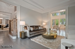 Living Room featuring hardwood floors, crown moldings, Bay windows, paneled walls