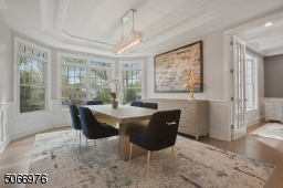 Dining Room featuring hardwood floors, paneled walls, recessed ceiling, 4 Bay double windows with transom windows and modern light fixture