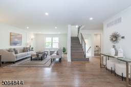 Open area between dining room and living room access to stairs to second floor, basement, kitchen and mud room