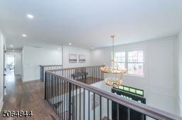 Open second floor hallway overlooking two story entry hall