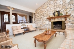 Entire wall of stone to cathedral ceiling, with fireplace, this oversized room has wall of glass with sliders to deck.