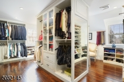Primary Dressing Room / Walk-In Closet featuring built-in ?furniture? and windows