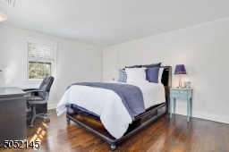 Bedroom 3 featuring hardwood floors, two exposures of windows and closet