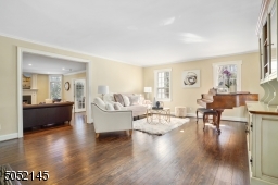 Living Room is open to Foyer & features hardwood floors, deep baseboard moldings, wood burning fireplace, built-in open shelving w/ lower cabinetry&2 sets of French doors which lead to glass enclosed Sunroom / Office and Family Room