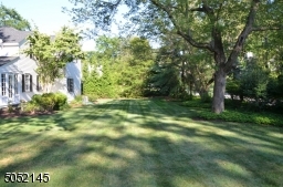 Lushly landscaped property with mature plantings and flower beds