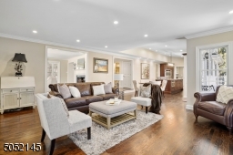 Family Room is step down from Living RM & Foyer, open concept to EIK & features hardwood floors, baseboard moldings, recessed lights, fireplace w/ built-in flatscreen TV flanked by oversized windows, French sliders to deck / patio