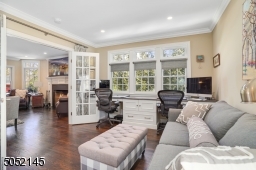 En-suite Guest Suite / Office featuring hardwood floors, recessed lights, custom wall-to-wall dual desk workspace with built-in cabinetry and triple window with transom and access to Full Bath