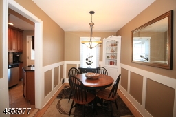Inviting Dining Room features built-in corner cabinet and custom wainscoting