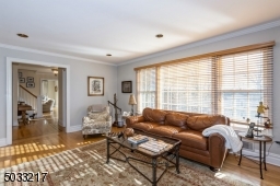 Another sun drenched room with hardwood floors and wood burning fireplace