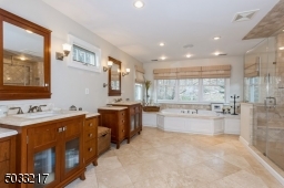 Custom Wood vanities with beautiful lighting and Travertine tile floor