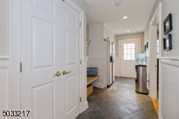 Mudroom with side entrance, extra fridge, extensive storage, coat closet and butcher block bench seating