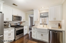 Renovated in 2019! Features include crisp white cabinetry, classic farm sink, brass hardware & faucet, gleaming quartz countertops and engineered hardwood flooring!