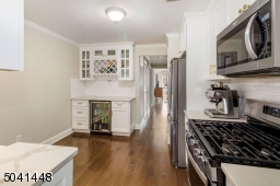 Attractive bar area with built-in beverage refrigerator, wine rack, glass display cabinetry and quartz countertops.
