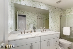 Main full bath sports a new white double vanity with lovely quartz countertops, and a new commode.