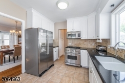 This delightful eat in kitchen featuring top-notch stainless steel appliances and custom cabinetry is a great space for prepping meals while keeping an eye on the little ones in the fenced in back yard.