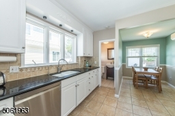 This delightful eat in kitchen featuring top-notch stainless steel appliances and custom cabinetry is a great space for prepping meals while keeping an eye on the little ones in the fenced in back yard.
