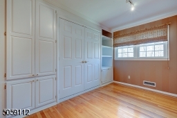 With custom wall including a murphy bed, craft table and bookshelves.