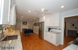 conveniently expands to the far end where all the days meals are served and a lovely wood burning  fireplace  with custom mantel and granite hearth is the focal point.