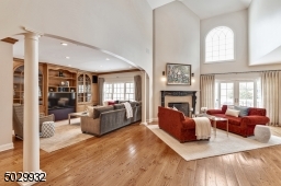 The expansive great room with it's impressive 20' 2-story ceiling, gas fire place, Bertch custom cabinetry with wet bar, wine refrigerator and wide plank wood floor is a terrific entertaining space.