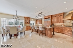 Open concept custom kitchen with Bertch cabinetry, granite countertops, center island breakfast bar with butcher block, Sub-zero refrigerator/freezer, Dacor 36" 5 burner gas cooktop & vented hood, Decor double oven & 2 Miele dishwashers.