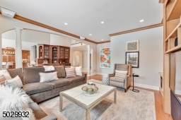 Wide plank wood floor, pillars, custom built-in book shelves & cabinetry with surround sound speakers.