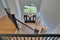 The grand entryway is open and elegant. The large window above the door and elegant glass detailed doors make this foyer welcoming and warm.