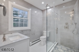 Gorgeous luxury master bath featuring a  large frameless glass enclosed Rain Shower