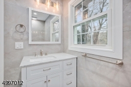 Full master bath with decorative porcelain tiles and wood vanity.