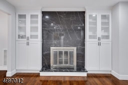 Wood burning fire place in the living room, with porcelain tile & custom cabinetry on the both side