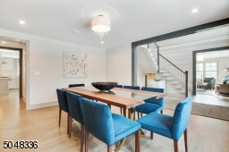 Dining Room is open to Foyer and features hardwood floors, deep baseboard moldings, triple double hung window, modern bubble chandelier, recessed lights, built-in speakers and custom drapes