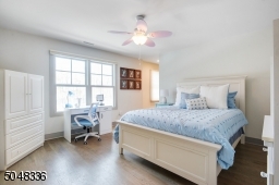 En-suite Bedroom features hardwood floors, baseboard moldings, walk-in closet, and 2 sets of double hung windows