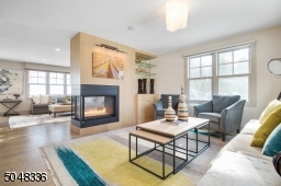 Chic "greige" hardwood floors throughout set the tone for this tremendous home. A stunning two-sided gas fireplace with built-ins and glass shelves make for seamless entertaining between the Living Room and Family Rooms.