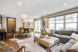 Family Room is open to the Kitchen & features hardwood floors, deep baseboard moldings, 2-sided gas fireplace w/ built-in shelves & flush cabinetry, recessed lighting, flush light fixture, two exposures of windows, double sliders to rear patio