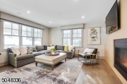 Chic "greige" hardwood floors throughout set the tone for this tremendous home. A stunning two-sided gas fireplace with built-ins and glass shelves make for seamless entertaining between the Living Room and Family Rooms.