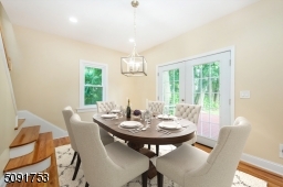 Dining room with french doors leading to the deck. Dining room has new hardwood floors, recessed lighting, and access to stairs leading to 2nd floor.