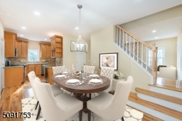Dining room with french doors leading to the deck. Dining room has new hardwood floors, recessed lighting, and access to stairs leading to 2nd floor.