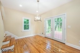 Dining room with french doors leading to the deck. Dining room has new hardwood floors, recessed lighting, and access to stairs leading to 2nd floor.