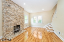 living room with new hardwood floors recessed lighting and allows access to 2nd floor stairs, sunken family room, and to the kitchen. Functioning fireplace.
