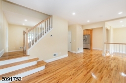living room with new hardwood floors recessed lighting and allows access to 2nd floor stairs, sunken family room, and to the kitchen.