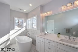 Double sink vanity, soaking tub and glass stall shower