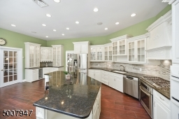 Custom cabinetry and wine refrigerator. Overlooks family room and backyard views.