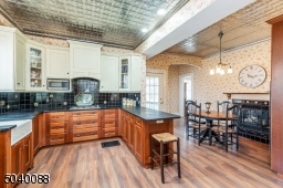 Gas fireplace, farmhouse sink, tin ceiling access to back staircase to 2nd floor, door to side deck, powder room