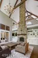 The soaring stone fireplace is flanked with bookcase and entertainment built-ins. Take in a heightened view of the architectural splendor from the open upper level.