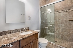 Bathroom accompanying 5th bedroom is handsomely turned out in stone and marble surfaces.