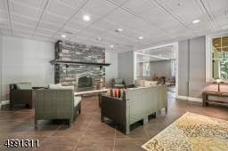 Gas-burning stone fireplace with raised hearth. The nearby Media area includes screen, projector, surround sound system, lighting sconces.