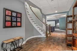Open floor plan is ideal for entertaining. Plumbing for future wet bar. Elegant "tile-look" drop ceiling. "Wood-Look" laminate tile flooring. Half bath, multiple storage closets, utility room. French doors lead to covered paver stone patio.