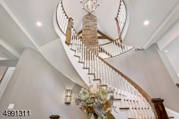 Solid wood 8-foot double entry doors open to the Foyer with dramatic curving staircase. Neutral wall palettes present a serene backdrop throughout. 10-foot ceilings on first level, 9-foot on second and walk-out lower.