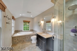 Master bath with jetted tub and seamless glass shower doors.