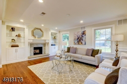 The Living Room features an attractive raised-hearth wood burning Fireplace with marble surround, custom wood mantel and is flanked by custom-designed cabinetry.